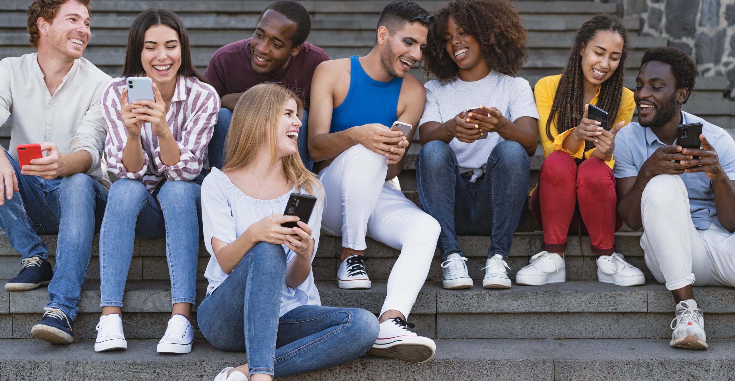 Junge, diverse Creator-Gruppe filmt sich lachend mit Handys für Social Media.